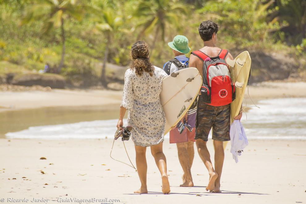 Imagem de amigos surfistas andando e admirando a Praia da Engenhoca.